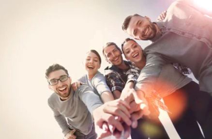 Smiling group of friends stacking their hands together