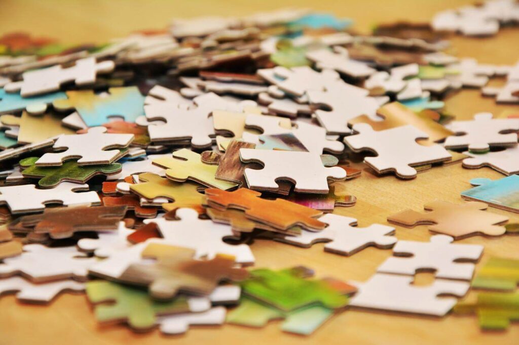 Scattered colourful jigsaw puzzle pieces on a wooden table