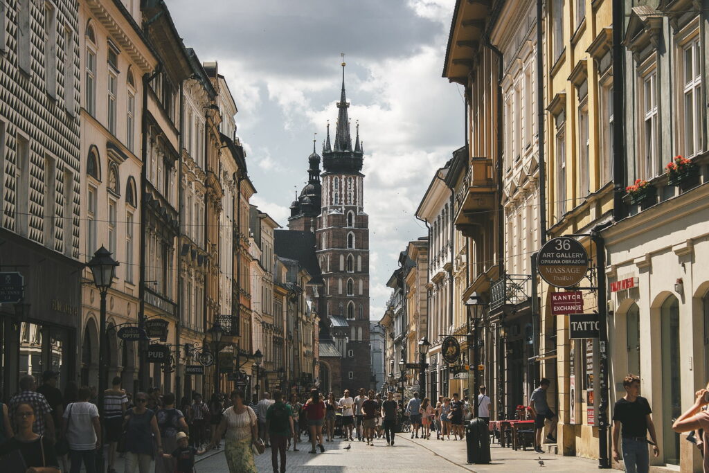 Tłum spacerowiczów na ulicy Floriańskiej, w tle wieża Kościoła Mariackiego